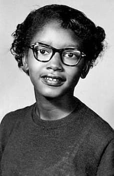 A school photograph of Claudette Colvin, probably about age 15. She wears glasses and smiles at the camera.