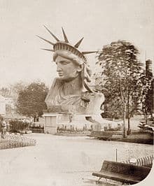 This is a  black-and-white photo of the head and crown of the Statue of Liberty. It was on display in a park in Paris.