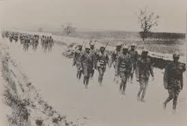 This photograph shows Harlem Hellfighters marching along the road.