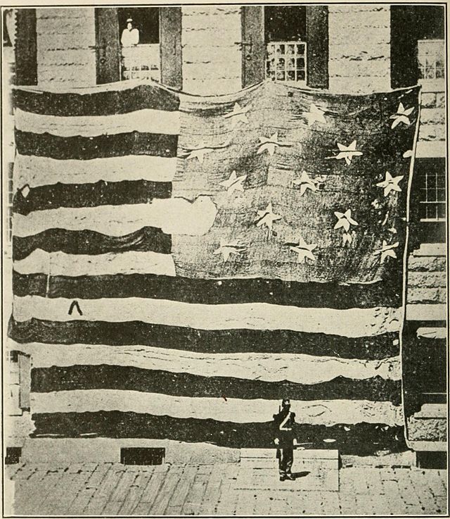 A black-and-white photograph from 1873 showing the damage that the flag endured during the fighting.
