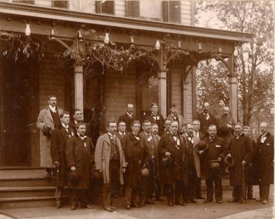 This is a black-and-white photograph of a group of businessmen or politicians who have come in to meet William McKinley. 
