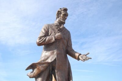 This is a color photograph of the statue outside the Library. The photographer shot from below so the viewer sees blue sky and Lincoln as if he were in the midst of a speech.