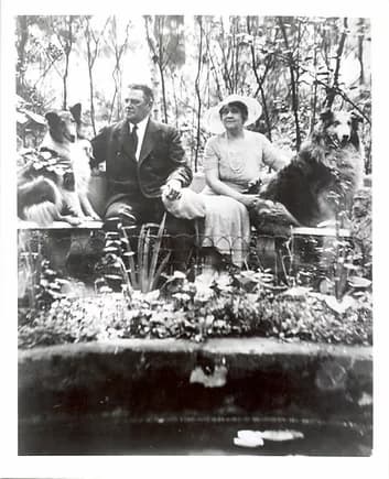 A black and white formal photo of Albert, Anice, and tow of the dogs. They are sitting among blooming flowers---a color photo would have been nice!