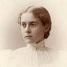 A sepia toned photo of a young Alice Hamilton. She wears a high-collar white blouse and her hair is pulled into a bun.