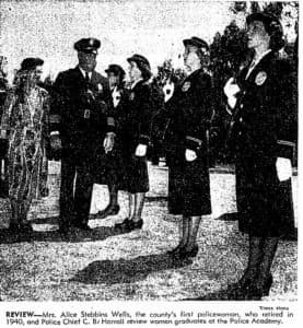This is a newspaper photo of Alice Wells and a police officer reviewing incoming women at the Police Academy. 