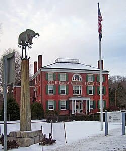 This is a photo from 2007 of the Elephant Hotel. The pole with the elephant is in the foreground. There is snow on the ground.