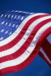 The U.S. flag waving against a blue sky.