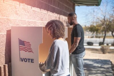 A current photo from istock showing two Black exercising their right to vote.