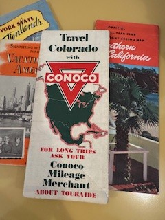 a collection of road maps from different companies. The most prominent in the photo is a Colorado map put out by Conoco.