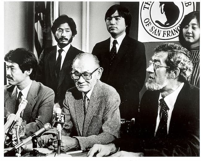 A black-and-white photograph of the press conference after the federal decision.