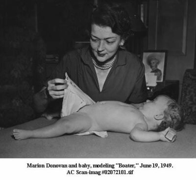 Photograph of Marion Donovan showing how she is putting a baby in one of her diaper covers. June 19, 1949