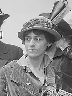 A black and white photo of Vorse on a trip. She wears a fashionable hat and is dressed in a corduroy coat.