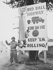 A black and white photo from World War II showing that the road ahead is one dedicated to the Red Ball Express.