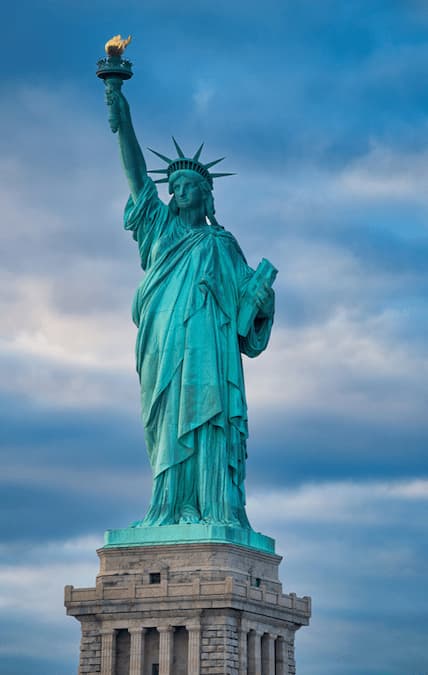 A color photo of the statue of liberty against a blue sky. istockphoto.com