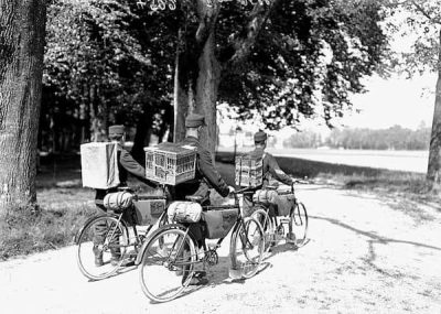 These soldiers are biking away with birds in baskets on their backs.