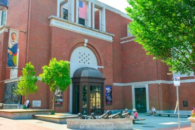 The exterior of the red brick Museum of the American Revolution.  There are cannons and benches in front.