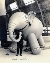 A black-and-white photo of Tony Sarg with an early balloon---a small, friendly-looking elephant.
