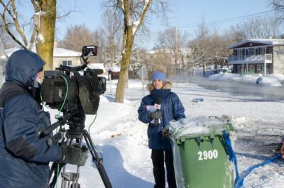 A photograph of a television newsperson reporting on a recent snowstorm