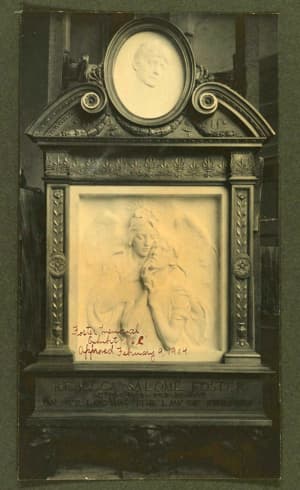 This color photo shows the marble likeness of Mrs. Foster atop a square marble relief of an angel with a child. It is in the original frame that was lost over time.