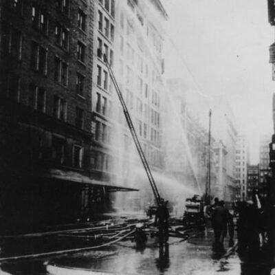 black and white photo from the era; the firefighters trying to extinguish the fire.