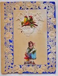 This valentine has birds and a young girl dressed in finery. There is a lace paper overlay for the blue background of the card.