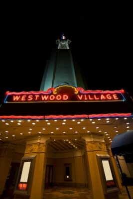 This is a nighttime photo of the Westwood Village theater looking upat the tower that dominates. 