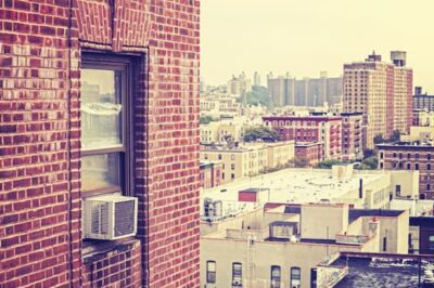 Window air conditioning unit in a big city. istockphoto.com